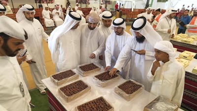 Prospective buyers inspect the dates on display at the Liwa Date Auction. Antonie Robertson / The National