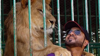 Jasim Ali Salim with a lion he rescued at his wildlife park in Ras Al Khaimah.