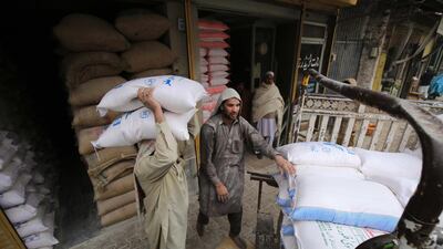 Labourers sort wheat flour sacks at a sale point during wheat flour dealers strike in Peshawar, Pakistan. The country saw its debt and liabilities rise by 40 per cent over the last 15 months. EPA