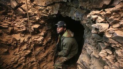 An Iraqi Shiite fighter from the Hashed Al Shaabi paramilitary forces inspects an underground tunnel in the town of Tal Abtah, south of Tal Afar, on December 10, 2016.