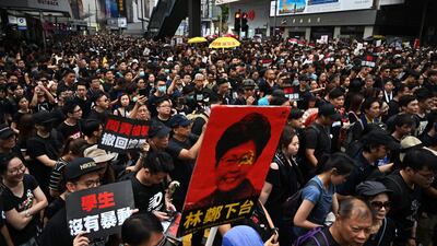A placard (C) with an image of Hong Kong's Chief Executive Carrie Lam is displayed as thousands of protesters dressed in black take part in a new rally against a controversial extradition law proposal in Hong Kong. AFP