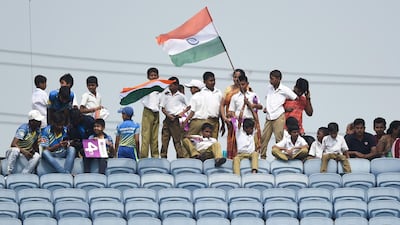 Schoolchildren wave India flags at the Maharashtra Cricket Association Stadium in Pune. AFP