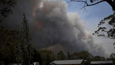 A home stands as smoke from the Grose Valley fire rises in the distance in Bilpin, west of Sydney. Reuters