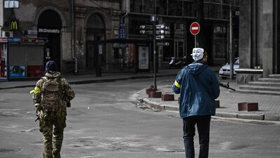 A member of the Ukrainian forces, wearing the Guy Fawkes mask popularised by Anonymous, patrols central Kiev. AFP