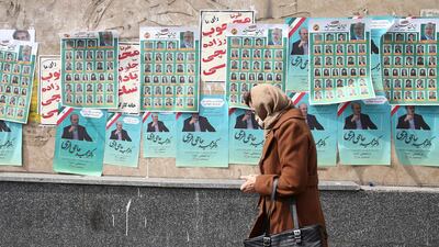 A woman walks past parliamentary election campaign posters in Tehran. Reuters