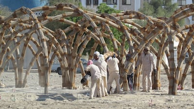 Workers assembling bundles of palm fronds to create a shelter for the Sabla Project