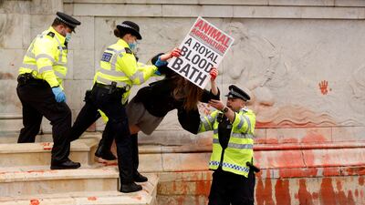 Police officers detain an Extinction Rebellion activist during a protest outside Buckingham Palace. Reuters