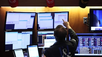 US President Donald Trump's signature Maga baseball caps are seen on the trading floor of the New York Stock Exchange. His continued pressure on lowering interest rates has kept investors in a wait-and-see approach. AFP