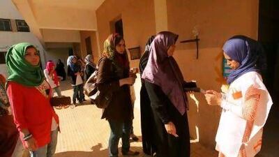 An electoral worker, right, verifies the identity of voters at a polling station during the National Assembly election in Benghazi today. Reuters