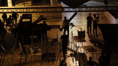 Israeli security forces take down security barriers at the Lions' Gate, a main entrance to the Al-Aqsa mosque compound in Jerusalem's Old City