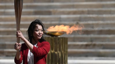 Former Japanese swimmer Imoto Naoko holds the Olympic torch during the Flame Handover Ceremony for the Tokyo 2020 Summer Olympics in Athens, Greece. Getty Images