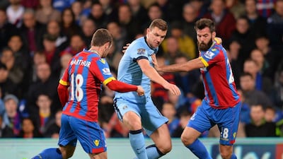 Manchester City's Edin Dzeko tries to dribble through Crystal Palace's James McArthur and Joe Ledley during their Premier League contest on Monday night. Glyn Kirk / AFP