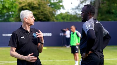 World XI manager Arsene Wenger speaks to Usain Bolt. PA