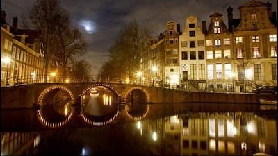 The Herengracht, one of the main waterways in Amsterdam's city centre, is crossed by a series of bridges that are lit romantically at night.