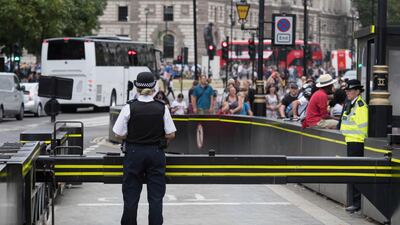 The area is packed with tourists as police secure the scene near a road barrier outside the Houses of Parliament in London, the day after a suspected terror attack, Wednesday Aug. 15, 2018. Stefan Rousseau/PA via AP