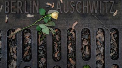 A flower is placed on a plaque detailing the transport dates and destinations of Jews sent from Berlin to various concentration camps between 1942 and 1944, at the Platform 17 (Gleis 17) memorial, next to the Gruenewald S-Bahn station in Berlin. AFP / John MACDOUGALL
