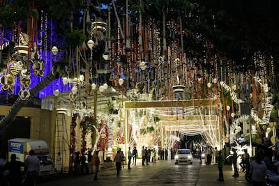 People walk past Antilia, the home of billionaire Mukesh Ambani, as it's lit up and decorated for Anant Ambani and Radhika Merchant's wedding. AP