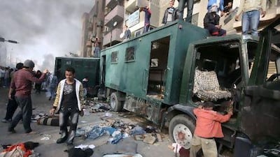 Anti-government protesters stand atop a police vehicle in Suez, Egypt.