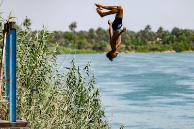 A young Iraqi dives into the Euphrates to cool off during a heatwave. AFP