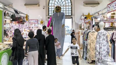 Stilt performers dressed in traditional Emirati clothes walk through the fair. Reem Mohammed / The National