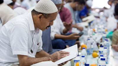 A man reads from the Quran before breaking his fast in Dubai.