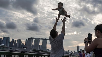 A man throws a young child into the air at a seaside park in Singapore. EPA