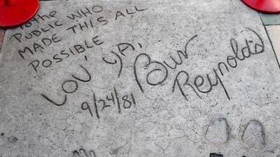 US actor Burt Reynolds wrote 'To the Public who made this all Possible, Lov Ya,' during his hand and foot prints in cement ceremony on 24 September 1981 at the TCL Chinese Theatre in Hollywood. EPA
