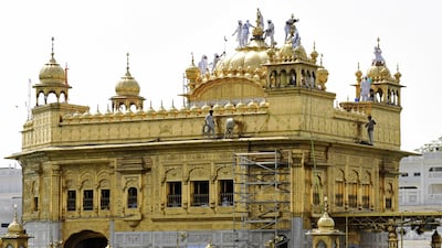 Volunteers from faith-based charitable organisation Guru Nanak Nishkam Sewak Jatha from Birmingham clean the gold plating of the Golden Temple in Amritsar. AFP