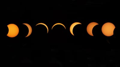 A composite image shows a sequence of the Moon passing in front of the Sun, as seen from Greenwich Park in London. EPA