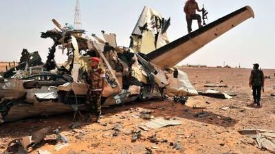 Rebels inspect an airplane destroyed by a NATO air strike at the Bir Durfan military base close to Bani Walid, on September 4, 2011. A special envoy for UN Secretary General Ban Ki-moon arrived in Libya as Libya's National Transitional Council have stepped up efforts to bring order and democracy to the country. AFP PHOTO/Carl de Souza *** Local Caption *** 751028-01-08.jpg