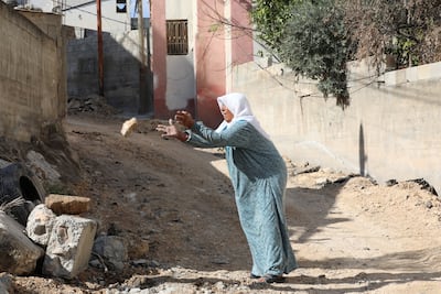 A Palestinian woman clears rubble after the Israeli raid in Jenin. EPA