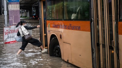 A woman boards a bus, which is still running despite major roads being submerged. The Bangkok governor has urged residents to stay at home until the flooding subsides. Getty Images