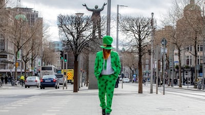 A man celebrating St Patrick's Day strolls in the O'Connell Street area of Dublin on March 17, 2020, as St Patrick's Day festivities are cancelled and pubs shut in reaction to the Covid-19 outbreak. AFP