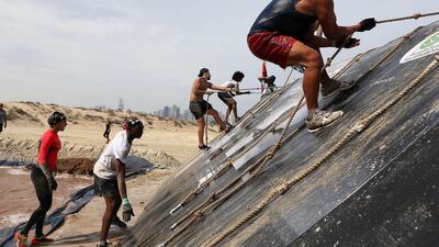 A man pulls himself up an obstacle.