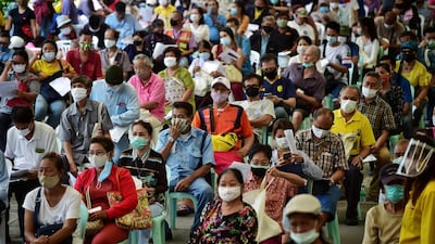 People wearing face masks sit on chairs as they queue to file complaints for not yet receiving the 5,000 Thai baht financial assistance for those whose income is impacted by the Covid-19 coronavirus outbreak. AFP