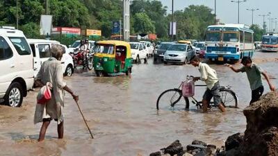 Vehicles pass along a water-logged road as the Yamuna River rises in New Delhi.