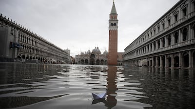 A boat made with a paper sheet floats in a flooded St. Mark's Square at Venice. AP Photo