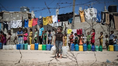 Palestinian children waiting to fill jerrycans and bottles with drinking water from public taps at the Dair Al Balah refugee camp in central Gaza Strip. Gazans are falling ill from their drinking water, as pollution of the seawater has gone beyond 50 percent, which would make Gaza uninhabitable by 2020 according to the UN. Lack of fuel to operate sewage treating facilities has forced the authorities to send wastewater into the Mediterranean Sea. Wissam Nassar