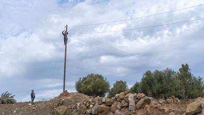 Workers repair an electricity line near a village in Rafid, on the outskirts of Quneitra, south-west Syria, after an Israeli incursion. AP