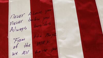 Messages written on a flag-draped coffin of one of the killed service members. Reuters