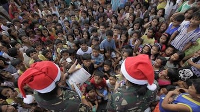 Volcano evacuees are entertained by soldiers wearing Santa hats at an evacuation centre in Legazpi city, 500km south-east of Manila.