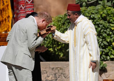 Prince Harry smells a cedar wood box as he and Meghan visit a Social Entrepreneurs event and market in Rabat. AP