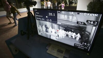 Passengers walk past a thermal scanner at the quarantine area in arrivals at Manila International Airport in the Philippines. The country is one of 18 that have reported cases of the Mers coronavirus. Aaron Favila / AP Photo