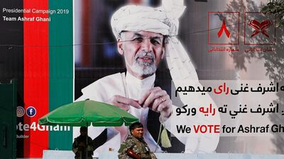 A member of the Afghan security force stands in front of a poster of Afghan presidential candidate Ashraf Ghani in Kabul, Afghanistan. Reuters