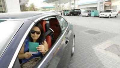 Lana Huniti reads a leaflet on self-service petrol at the Enoc station on Jumeirah Beach Road.