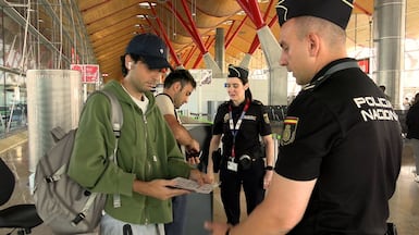 Spanish national police officers check the documents of travellers arriving from Italy. Reuters