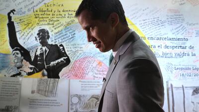 Venezuela's opposition leader Juan Guaidó, who declared himself the interim-president of Venezuela, stands next to a mural at the Popular Will party's headquarters, in Caracas, Venezuela, Friday, May 10, 2019. AP