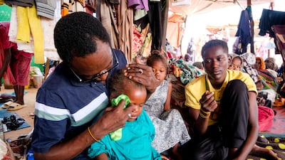 A displaced Sudanese man wipes the tears of his deceased sister's daughter at a displacement camp in Al Dabba, Sudan. Reuters