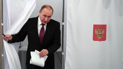 President Vladimir Putin walks out of a voting booth at a polling station during Russia's presidential election in Moscow. Yuri Kadobnov / AFP