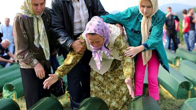 Bosnian women by the coffins of their relatives at the Potocari Memorial Centre during the burial of the remains of 409 newly-identified Bosnian Muslims as part of a memorial ceremony to mark the 18th anniversary of the Srebrenica Massacre in Srebrenica, Bosnia and Herzegovina July 11, 2013. EPA